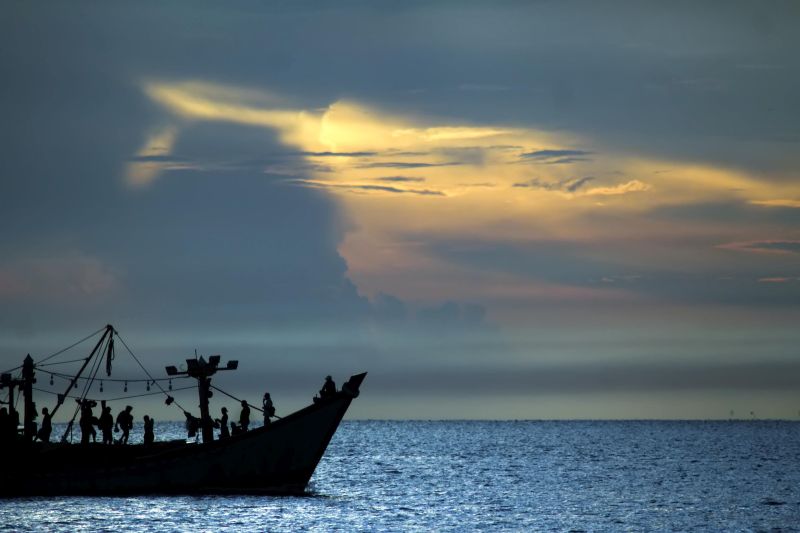 Kapal nelayan melintas dengan latar belakang matahari terbit di perairan Selat Malaka, Lhokseumawe, Aceh, Rabu (8/4/2020). Foto Antara/Rahmad.