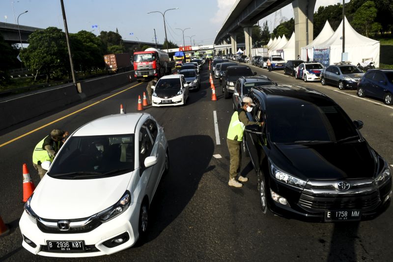 Petugas gabungan memeriksa kendaraan yang akan masuk ke wilayah DKI Jakarta di KM 47 Tol Cikampek-Jakarta, Jawa Barat, Sabtu (30/5/2020). Foto Antara/Muhammad Adimaja.