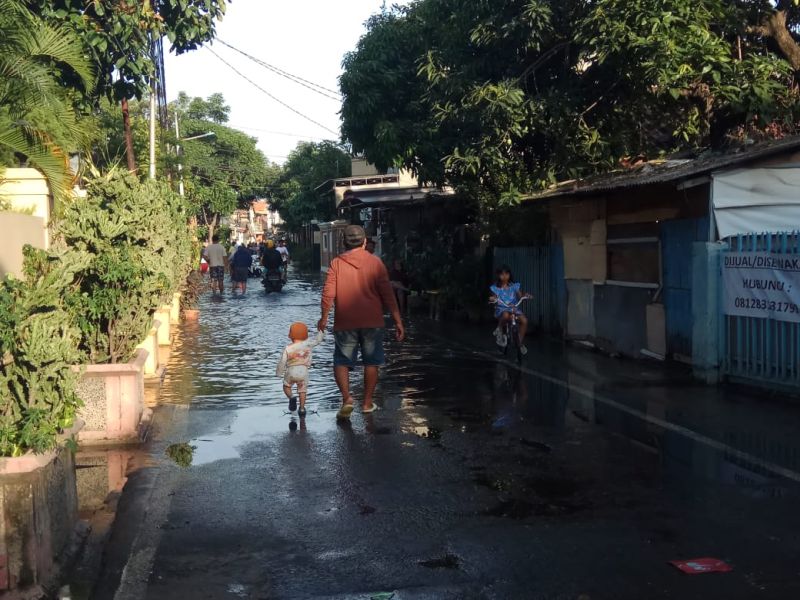 Beberapa warga berusaha melintas genangan air banjir di Rawa Buaya, Cingkareng, Jakarta Barat, Minggu (21/2). Alinea.id/Kudus Purnomo Wahidin.