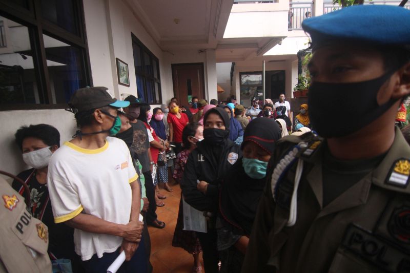 Sejumlah warga antre saat pembagian bantuan sosial dari pemerintah Provinsi Banten di Poris, Kota Tangerang, Banten, Rabu (29/4/2020). Foto Antara/Fauzan.