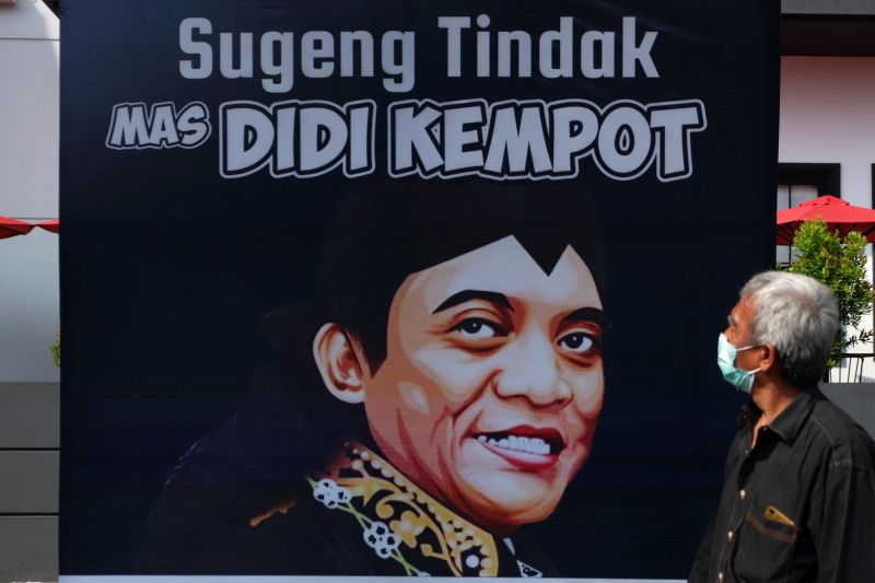   Warga melewati poster ucapan duka cita untuk mengenang penyanyi campursari Dionisius Prasetyo atau Didi Kempot yang meninggal dunia di Solo, Jawa Tengah, Selasa (5/5/2020). Foto Antara/Maulana Surya.