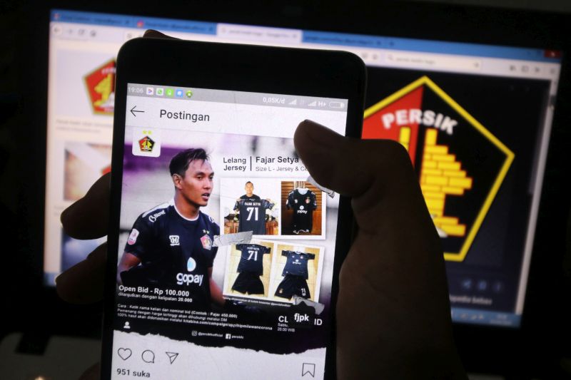 Warga mengamati akun instagram kiper Persik Kediri Fajar Setya Jaya di Kota Kediri, Jawa Timur, Kamis (2/4/2020). Foto Antara/Prasetia Fauzani.