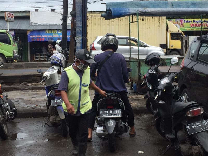 Didi Hendrayana tengah membantu memarkir sepeda motor di kawasan rumah toko, Pomad, Kota Bogor, Jawa Barat, Kamis (28/1/2021). Alinea.id/Rohman Wibowo.