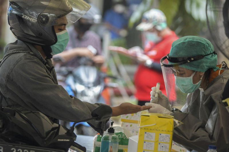 Petugas medis mengambil sampel darah jurnalis saat Rapid Test COVID-19 secara Drive-Thru di Halaman Gedung Kementerian Komunikasi dan Informatika, Jakarta, Rabu (8/4/2020). Foto Antara/Galih Pradipta.