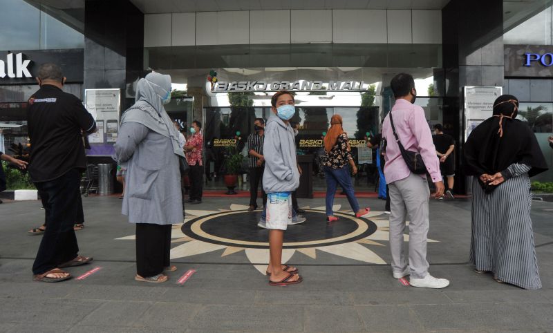 Sejumlah pengunjung mengikuti prosedur jaga jarak fisik dan diperiksa suhu tubuhnya sebelum memasuki mal di Padang, Sumatera Barat, Rabu (20/5/2020). Foto Antara/Iggoy el Fitra.