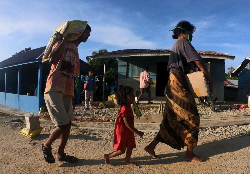 Warga Suku Anak Dalam (SAD) atau Orang Rimba Jambi membawa paket bantuan yang diterimanya di Permukiman SAD, Pelepat, Bungo, Jambi, Selasa (19/5/2020). Foto Antara/Wahdi Septiawan.