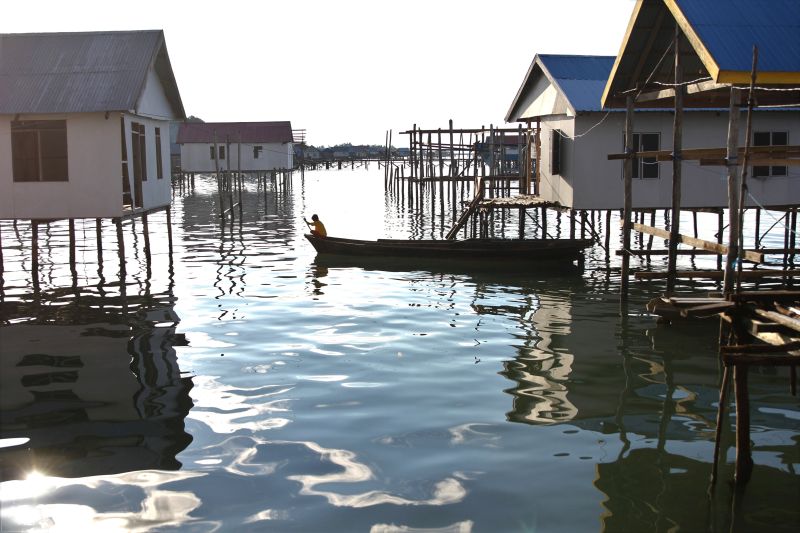  Seorang anak Suku Bajo menggunakan perahu melintas di antara rumah yang telah dibedah dangan anggaran desa agar menjadi layak huni di Desa Lepee, Konawe, Sulawesi Tenggara, Jumat (17/4/2020). Foto Antara/Jojon.