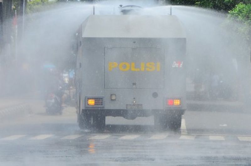 Kendaraan taktis Polres Kudus menyemprotkan cairan disinfektan di jalan utama kota Kudus, Jawa Tengah, Selasa (31/3). /Foto Antara