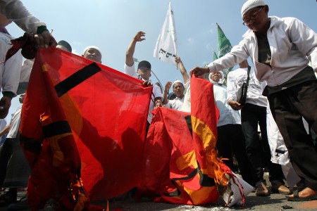 Massa Front Pembela Islam (FPI) dan Front Pancasila membakar kain bersimbol komunis di depan Gedung Negara Grahadi, Surabaya, Jawa Timur, Kamis (28/4/2016). /Foto Antara