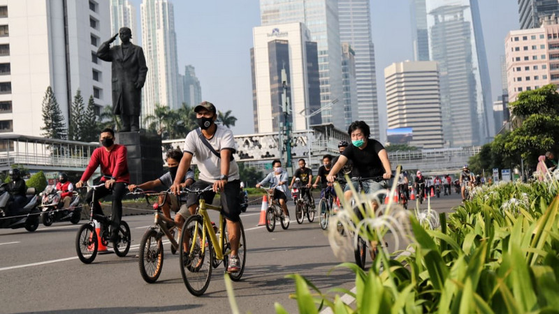 Pesepeda menggunakan masker di tengah pandemi Covid-19 saat melintasi jalan protokol Jakarta, Minggu (14/6). Foto Twitter @aniesbaswedan