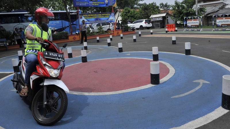 Petugas Satlantas Polres Serang mengawasi warga yang mengikuti ujian SIM C di Mapolres Serang, Banten, Jumat (3/11/2017). Foto Antara/Asep Fathulrahma.