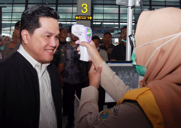 Petugas dari Kantor Kesehatan Pelabuhan Klas 1 Soetta memeriksa suhu tubuh Menteri BUMN Erick Thohir saat melakukan peninjauan kesiapan Bandara dalam menghadapi Covid-19 di Terminal 3 Bandara Soekarno Hatta, Tangerang, Banten, Rabu (11/3/2020). Foto Antara/Muhammad Iqbal.