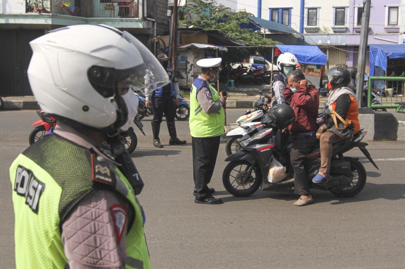 Petugas Kepolisian bersama Dishub memberikan sosialisasi kepada pengendara jelang penerapan PSBB Kota Depok di Jalan Arif Rahman, Depok, Jawa Barat, Minggu (12/4). /Foto Antara