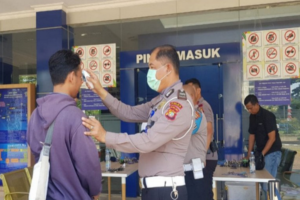 Petugas memeriksa suhu tubuh pemohon SIM sebagai salah satu protokol pencegahan Covid-19 di Satpas SIM Ditlantas Polda Metro Jaya, Daan Mogot, Jakarta Barat, beberapa waktu lalu. /Foto Antara.