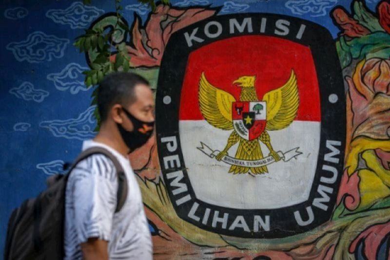 Warga melintas di depan mural bertema pemilihan umum di kawasan Pasar Anyar, Kota Tangerang, Banten, Kamis (7/5/2020). Foto Antara/Fauzan.
