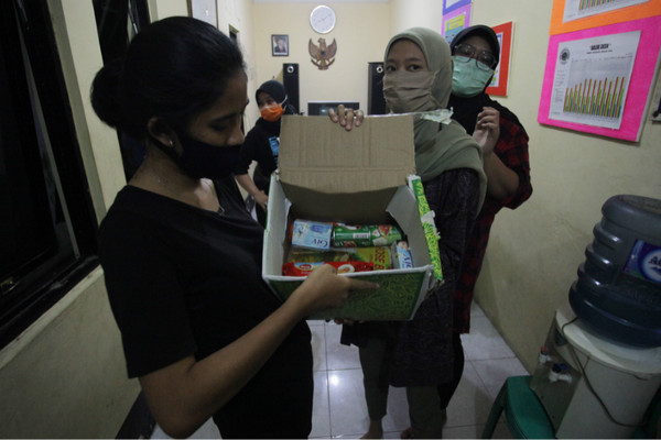 Warga memperlihatkan isi bantuan sembako pemerintah sebagai bantuan pangan akibat wabah Covid-19 di kawasan RW 03 Kebon Kacang, Jakarta, Minggu (12/4). Foto Antara/Reno Esnir