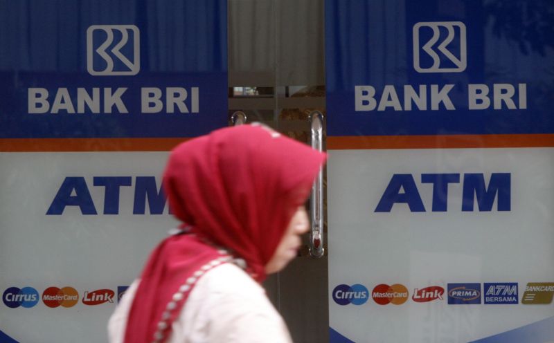 Seorang wanita melintas di depan Anjungan Tunai Mandiri (ATM) BRI di Jakarta. Foto Reuters/Crack Palinggi.