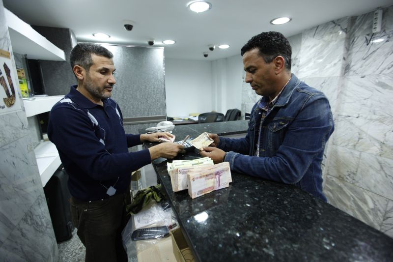 Seorang warga negara Libya menukar dirham Uni Emirat Arab menjadi dinar Libya di kantor penukaran dinar dirham di Tripoli, Libya. Foto Reuters/Ismail Zitouny.