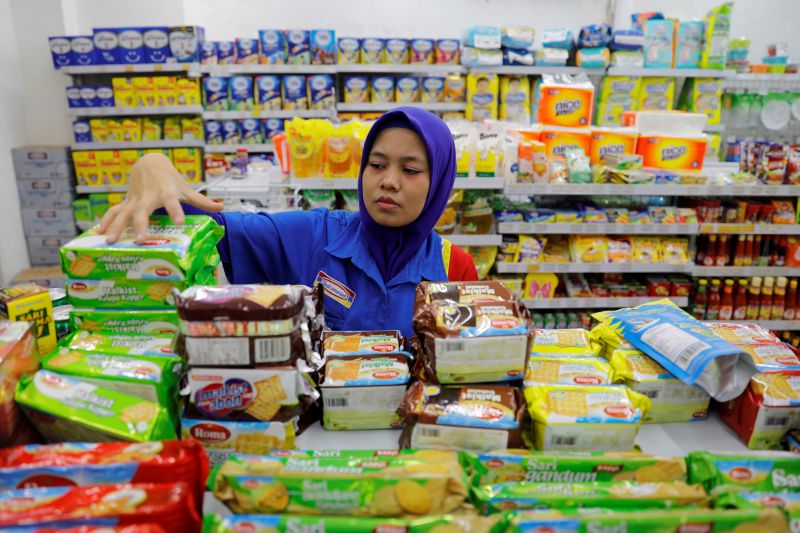 Seorang penjaga minimarket menyusun makanan kemasan untuk dijual di sebuah minimarket di Jakarta. Foto Reuters/Willy Kurniawan.
