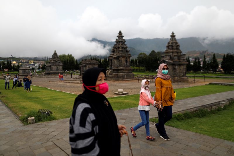 Pengunjung mengenakan masker saat berjalan di Candi Arjuna dalam Kompleks Pegunungan Dieng, Banjarnegara, Jawa Tengah, 15 November 2020. Foto Reuters/Willy Kurniawan.