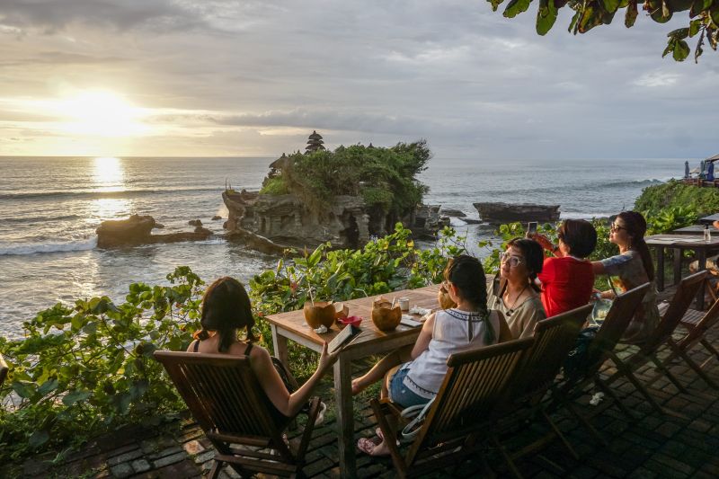 Sejumlah turis menikmati matahari terbenam di Tanah Lot, Bali 31 Desember 2020 lalu. Foto Reuters/Dicky Bisinglasi.