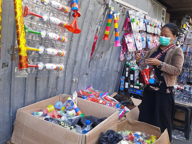 Rohmanah menyiapkan barang dagangan berupa terompet plastik, di kawasan Pasar Pagi Asemka, Jakarta Barat. Minggu (28/12). Alinea.id/Qonita Azzahra.