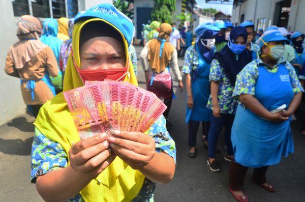 Pekerja menunjukkan uang THR Lebaran yang diterimanya di pabrik rokok PT Djarum Kudus, Jawa Tengah, Selasa (12/5/2020)/Foto Antara/Yusuf Nugroho.
