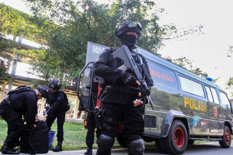 Anggota Polri bersenjata lengkap saat melakukan penggeledahan terduga teroris di Riau (06/02/18). Foto Antara.