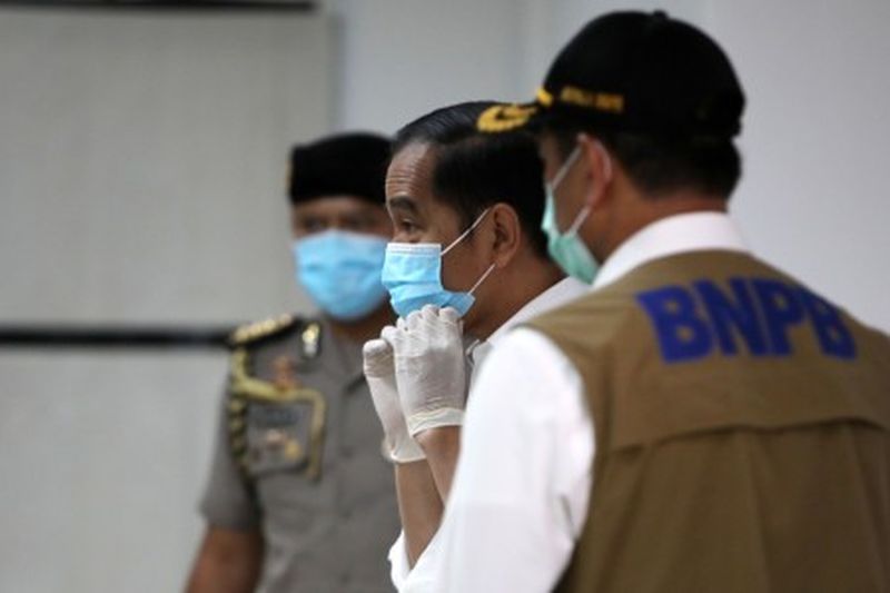 Presiden Joko Widodo mengenakan masker saat meninjau ruang perawatan Rumah Sakit Darurat Penanganan COVID-19 Wisma Atlet Kemayoran, Jakarta, Senin (23/3). /Foto Antara