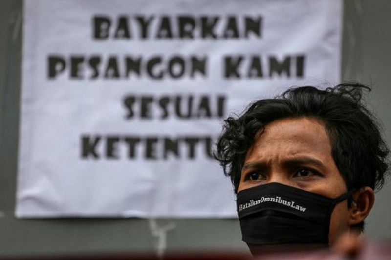 Seorang buruh menggelar aksi unjuk rasa di depan pabriknya di Benda, Kota Tangerang, Banten, Jumat (1/5). /Foto Antara