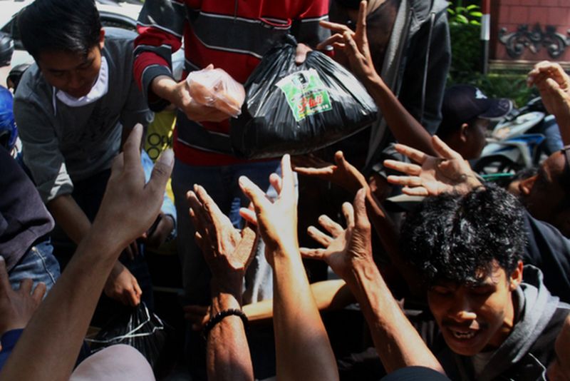 Warga berebut sembako yang dibagikan KAHMI di samping Balaikota Malang, Jawa Timur, Rabu (22/4/2020). Foto Antara/Ari Bowo Sucipto.