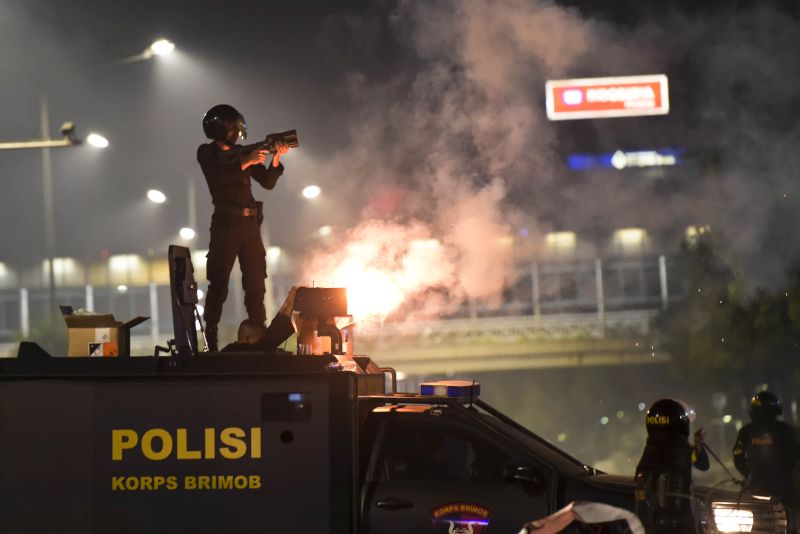 Polisi menembakkan gas air mata saat mengamankan kerusuhan 22 Mei di depan Gedung Bawaslu, Jakarta./ Antara Foto