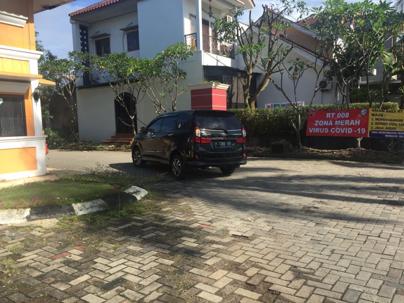 Spanduk peringatan kawasan zona merah yang membentang di samping gerbang perumahan Bukit Cimanggu City, Kota Bogor, Jawa Barat, Kamis (11/2/2021). Alinea.id/Rohman Wibowo.