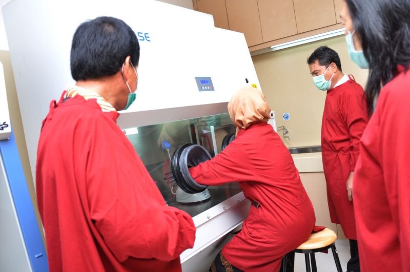 Petugas Kemenkes mengoperasikan cara kerja alat Polymerase Chain Reaction (PCR) untuk pemeriksaan spesimen swab tenggorokan pasien terduga Covid-19 di Laboratorium Rumah Sakit USU Medan, Sumatera Utara, Kamis (16/4/2020). Foto Antara/Septianda Perdana.