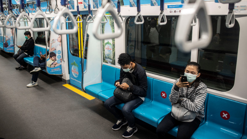 Penumpang duduk di bangku yang diberi stiker panduan jarak antarpenumpang di rangkaian gerbong kereta MRT, Jakarta, Jumat (20/3/2020). Foto Antara/Aprillio Akbar