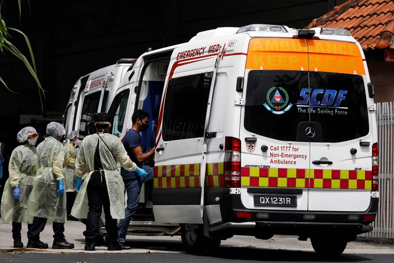 Anggota medis membantu pekerja migran masuk ke ambulans di tengah pandemi Covid-19 di Singapura, Selasa (28/4). Foto REUTERS/Edgar Su.