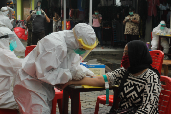 Petugas medis melakukan tes diagnostik cepat Covid-19, di Pasar Sore Manukan, Surabaya, Jawa Timur, Jumat (22/5)/Foto Antara/Didik Suhartono.