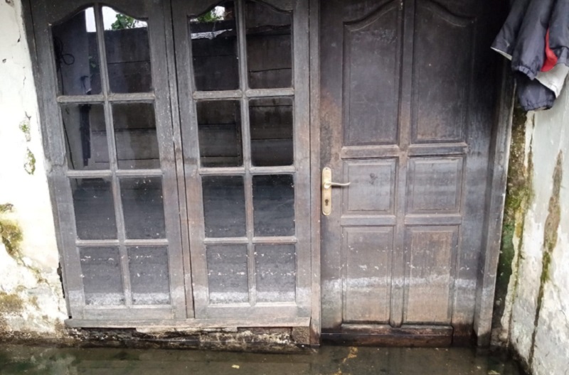 Air menggenang di depan pintu rumah warga di Gang Cue, Duren Jaya, Bekasi, Jawa Barat, Senin (20/3). Alinea.id/Kudus Purnomo Wahidin