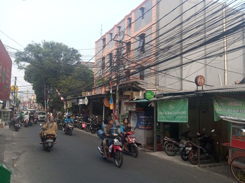  Situasi lalu lintas dengan pemandangan kabel semrawut di atas di Jalan KH. Syahdan, Kemanggisan, Palmerah, Jakarta Barat, Minggu (6/8/2023). Alinea.id/Kudus Purnomo Wahidin