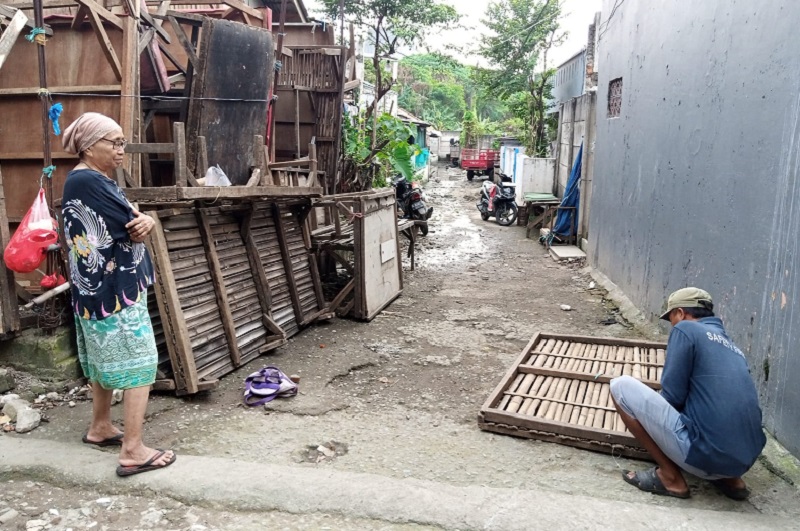 Sarmili (kanan), 57 tahun, tengah mereparasi meja dagangan di Gang Cue, Duren Jaya, Bekasi, Jawa Barat, Senin (20/3). Alinea.id/Kudus Purnomo Wahidin