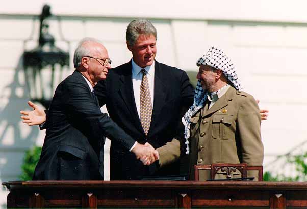  Pemimpin Palestina Liberation Organization (PLO) Yasser Arafat (kanan) berjabat tangan dengan pemimpin Israel Yitzhak Rabin di depan Presiden Amerika Serikat Bill Clinton usai menandatangani Oslo Accords pada 13 September 1993. /Foto Wikimediacommons