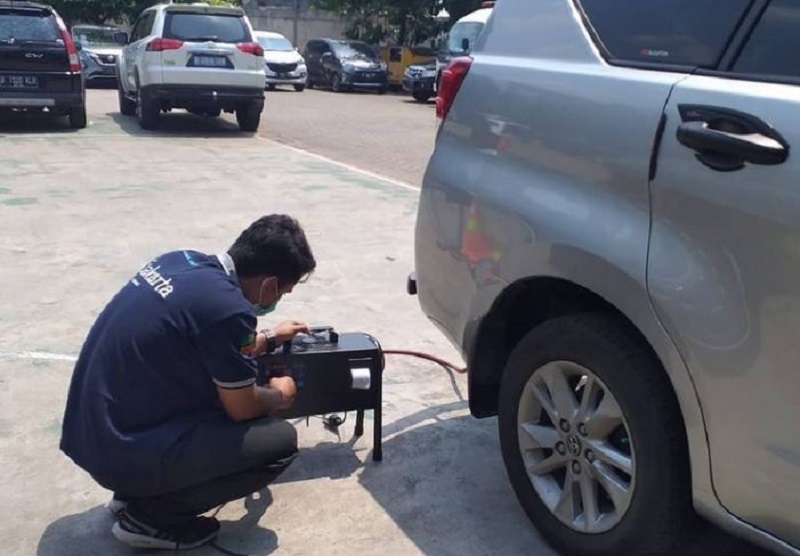 Petugas memeriksa emisi gas buang sebuah kendaraan roda empat di salah satu bengkel di DKI Jakarta. /Foto Instagram @uji_emisi_jakarta