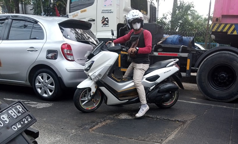 Seorang pengendara motor berzig-zag di antara mobil dan truk di salah satu ruas jalan di Kota Bekasi, Jawa Barat, Minggu (4/9). Alinea.id/Kudus Purnomo Wahidin