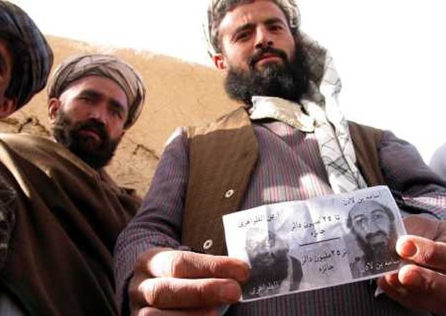 Seorang warga Afghanistan menunjukkan selebaran hadiah uang bagi mereka yang memberikan informasi mengenai keberadaan pemimpin Al Qaeda Osama bin Laden yang beredar pada November 2001. /Foto Wikimedia Commons