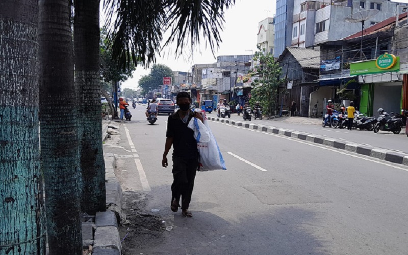 Seorang pemulung melintas di Jalan KH. Moh. Mansyur, Tambora, Jakarta Barat, Kamis (27/4). Alinea.id/Akbar Ridwan