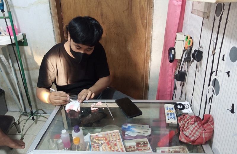 Abdul Aziz membuat cetakan gigi tiruan untuk pasien lansia di kiosnya di kawasan Benda, Tangerang, Banten, Senin (28/3). Alinea.id/Kudus Purnomo Wahidin