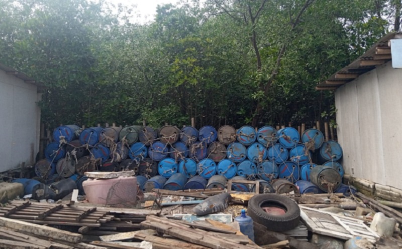 Drum-drum bekas berwana biru ditumpuk sebagai pembatas antara permukiman warga dan area konservasi mangrove di Muara Angke, Penjaringan, Jakarta Utara, Sabtu (14/1). Alinea.id/Kudus Purnomo Wahidin