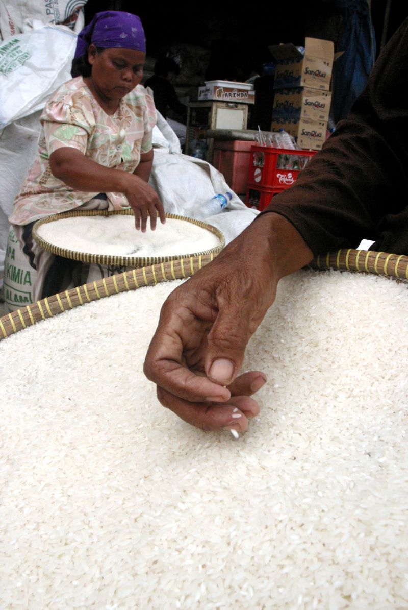 Pekerja menampi beras sebelum dijual di pasar. Foto Reuters/Oka Barta.
