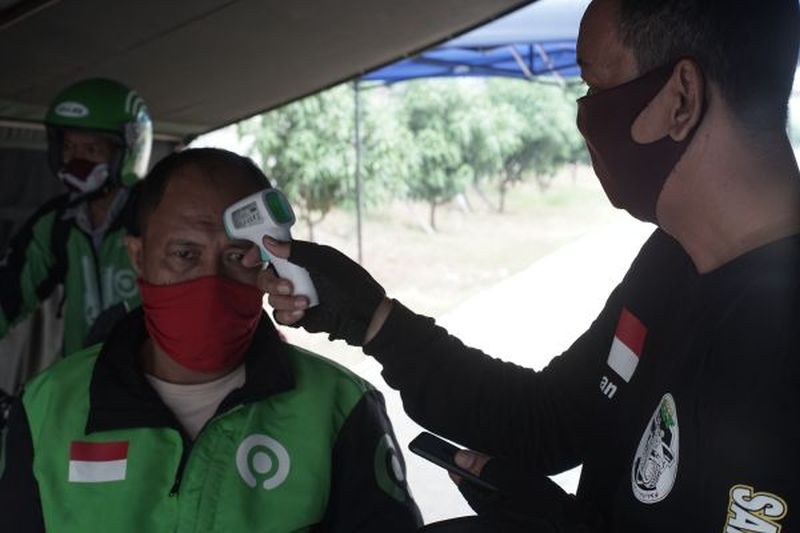 Mitra pengemudi Gojek menjalani pengecekan suhu tubuh. Foto Antara/Edwin Dala.