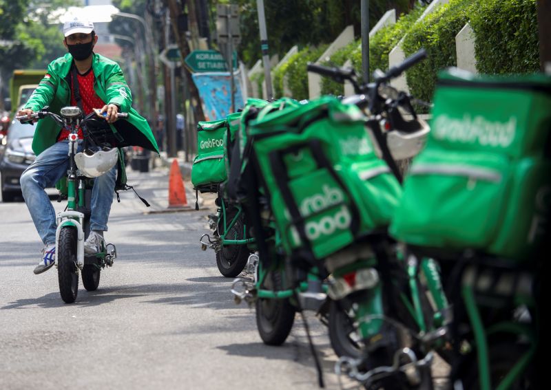 Mitra pengemudi GrabFood mengenakan masker saat mengantarkan pesanan makanan di jalanan Jakarta, Juli 2020. Foto Reuters/Ajeng Dinar Ulfiana.